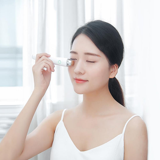 Woman using Aiyisheng Heated Bian Stone Eyes Massage Device for soothing eye relief